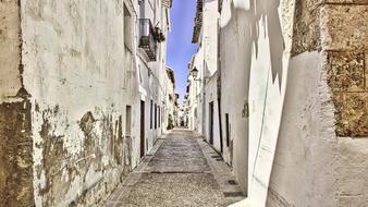 Beautiful, empty street among the houses in Spain, under the blue sky
