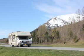 white van on the road near a mountain in alaska