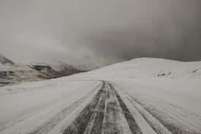 Landscape of the beautiful, snowy road on the mountains in clouds, in the winter