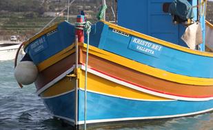 colorful wooden fishing boat anchored on water, Malta, Marsaxlokk