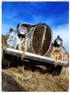 old rusty car on a field with dry grass