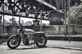 Landscape with the retro "Honda" motorcycle under the bridge, near the fence