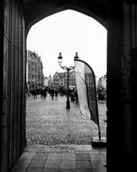 crowd of People on historical square, view through arched doorway