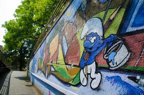 graffiti in the form of a smurf on a concrete wall