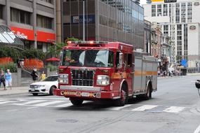 Colorful, shiny firetruck, cars and people on the Yonge Street in Toronto, Canada