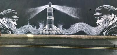 Beautiful, black and white graffiti with the men, near the lighthouse among the stones