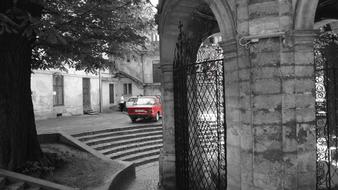 old red car in the old town in monochrome