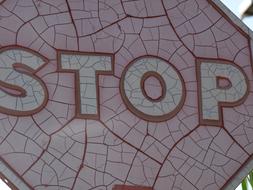 Old, red, white and pink "STOP" traffic sign