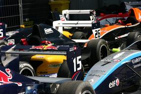 Colorful racing cars with signs, in light, on the race