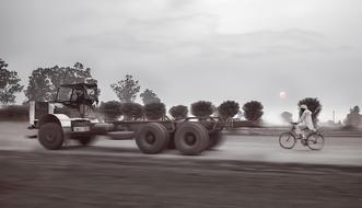 monochrome, movement of a truck and a bicycle on the road, india