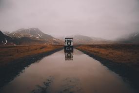 jeep driving on a wet mountain road