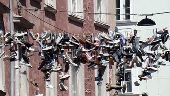 Close-up of the colorful shoes hanging on the street, near the building