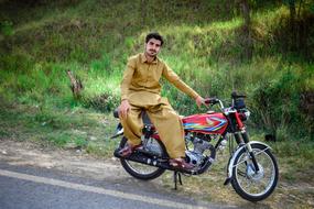 asian man sitting on a motorcycle