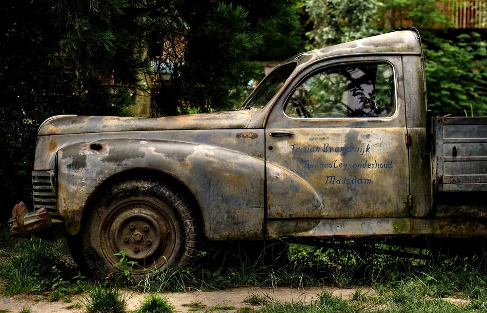 old rusty truck under the trees