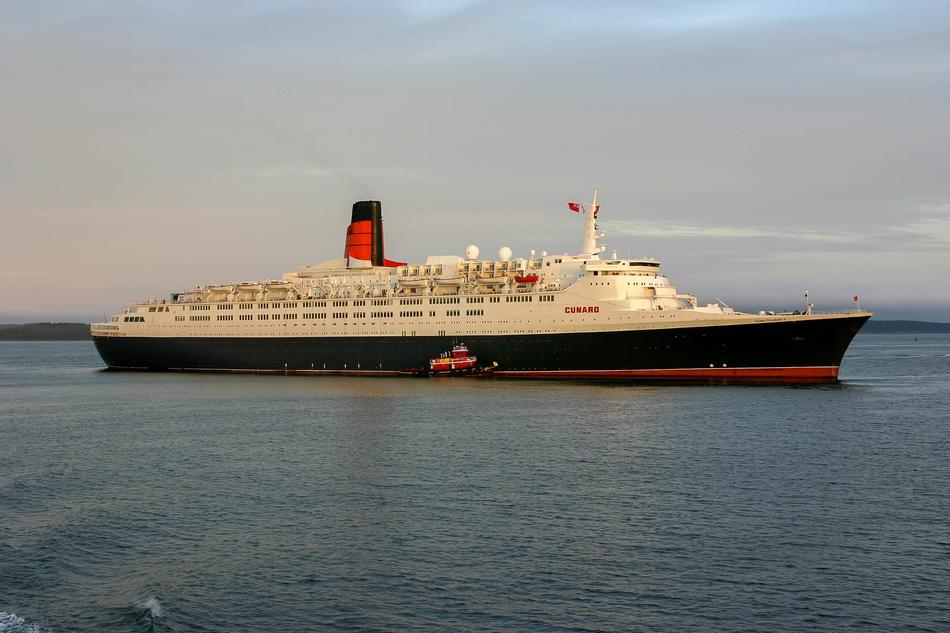 Big, colorful Queen Elizabeth 2 ship, on the beautiful waterscape, under the cloudy sky