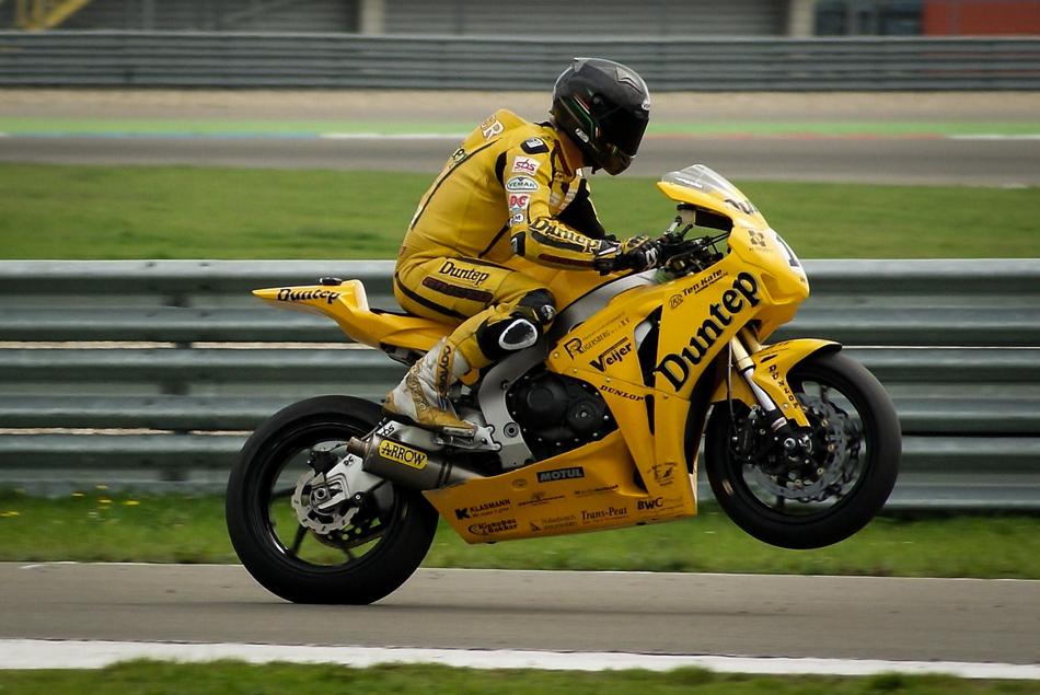 Racer on the racing bike, in helmet, on the road