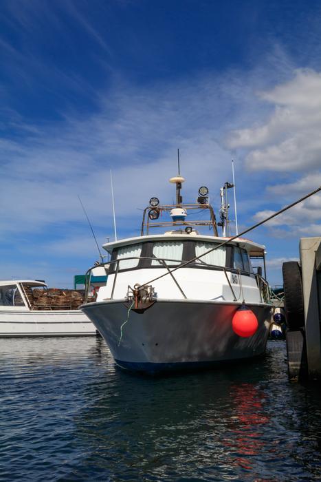 Boat on water, in the port of Tasmania in Australia, under the blue sky with clouds