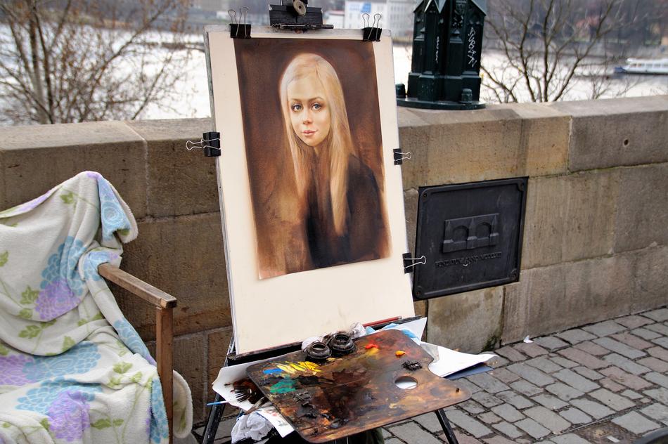 Beautiful painting of the blonde girl, on the street, near the plants in snow
