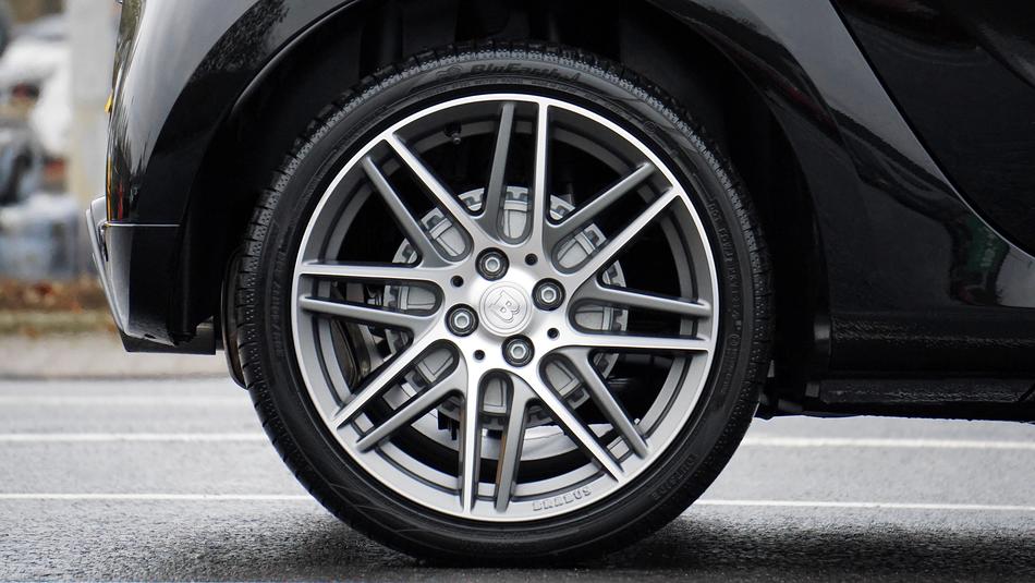 Close-up of the alloy vehicle of the car, on the road with lines