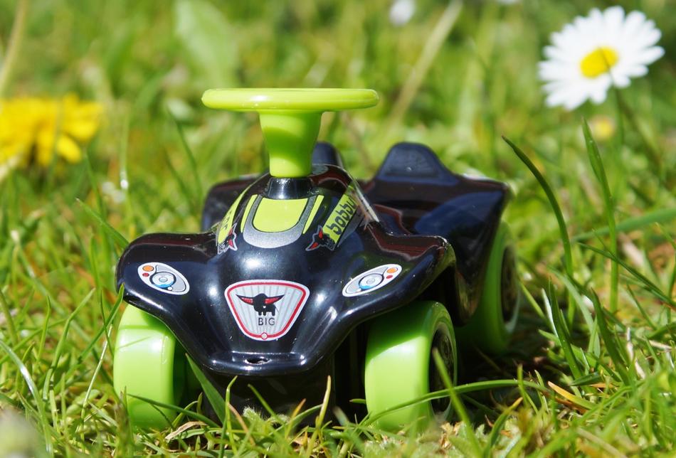 Bobby Car as a toy on the grass close up