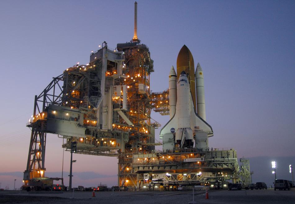 Space shuttle discovery with colorful lights, at beautiful and colorful sunset on horizon