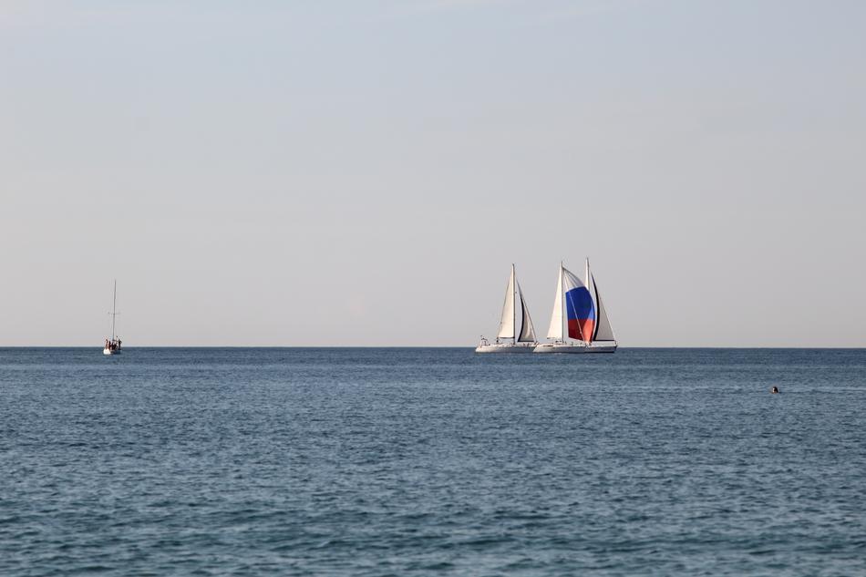 distant view of sailboats on the horizon to the sea