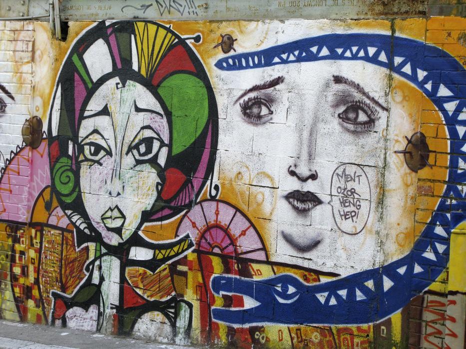 graffiti in the form of female faces on the wall of the building
