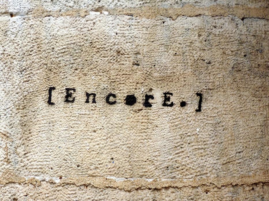 Black 'Encore' graffiti on the wall of the building