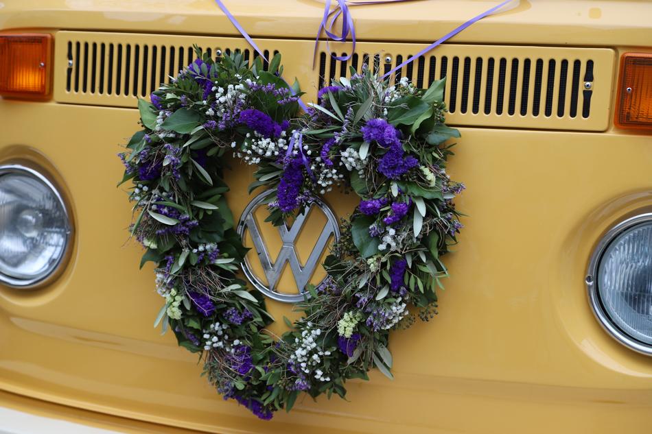 Close-up of the colorful and beautiful wreath with flowers, on the yellow 'Volkswagen T1' bus