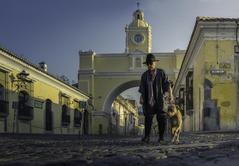 Man in hat, with the beautiful dog, in Antigua, Guatemala, under the blue sky