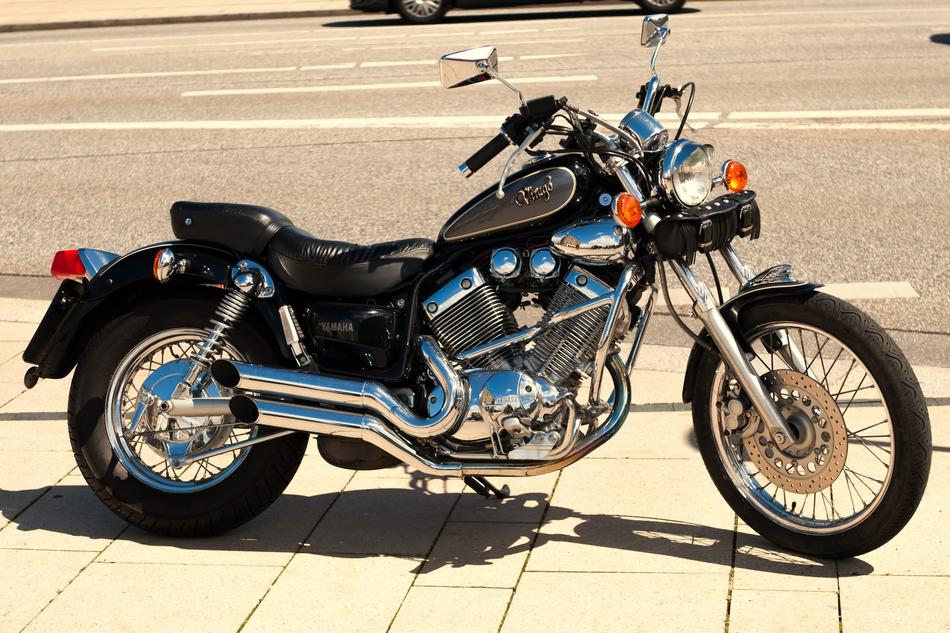 Shiny 'Yamaha' motorcycle on the pavement near the road, in sunlight