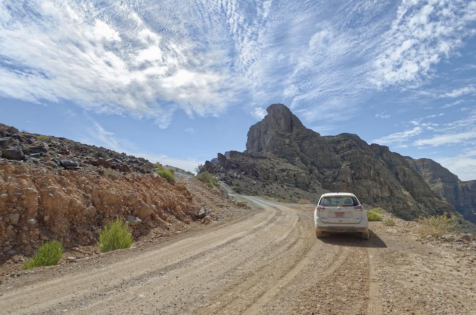 car on a dusty road in the mountains in the region ad dakhiliyah