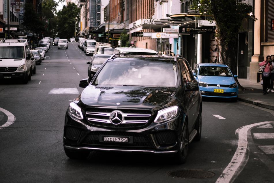 Shiny, black 'Mercedes' car among the other cars and buildings, on the street