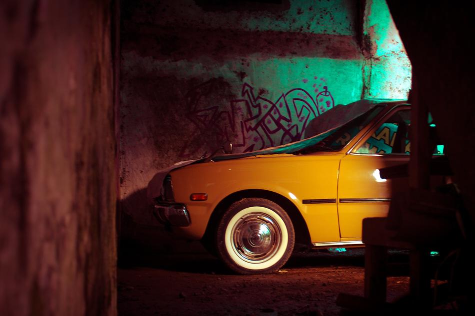 Car Yellow near the wall in a dark park