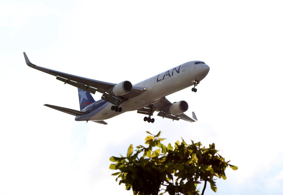 Low angle shot of the flying plane, above the airport Sao Paulo in Brazil, with the plant