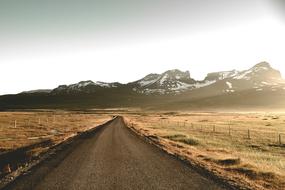 road, autumn field and mountains