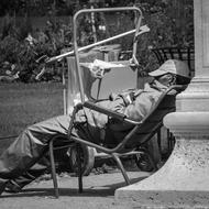 black and white, a man resting in a chair in the Tuileries Garden, Paris