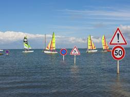 Signs standing in the water against the background of catamarans