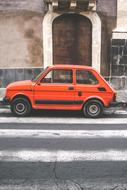 orange car on pedestrian cross road