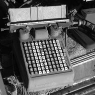 black and white, broken typewriter in a junkyard