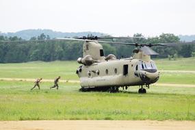 people running into a military helicopter