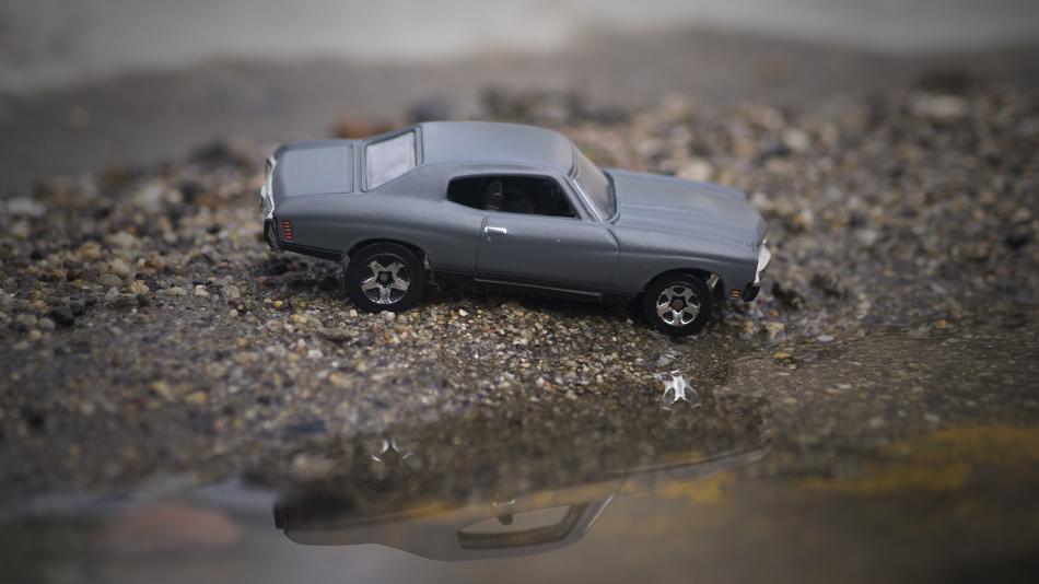 small grey car model by the water