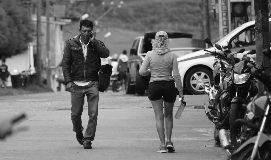 black and white photo of people on the road near the transport