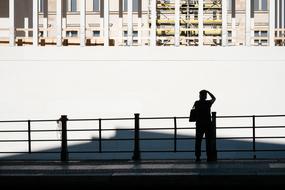 silhouette of a man against the background of a white building