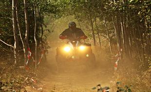 a man driving a car in the woods
