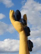 yellow hand sculpture with cars