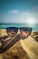 sunglasses on the sand on a sunny day