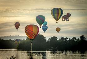 multicolored hot air balloons over the evening lake