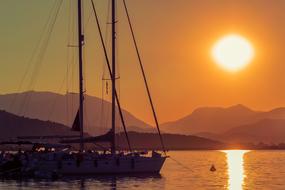 Sailing Boat anchored near scenic coast at sunset