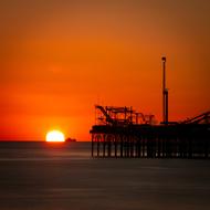 Silhouette of the pier among the water in Brighton, England at beautiful and colorful sunset